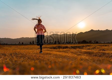 Asian Woman Enjoys Running Outside With Beautiful Summer Evening In The Countryside.