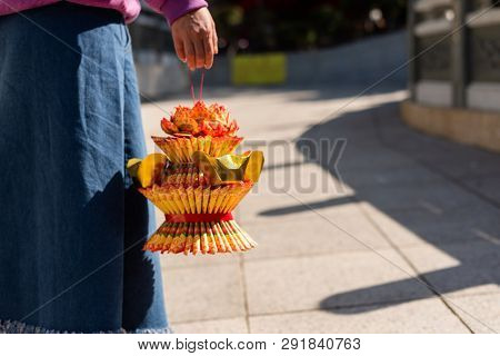 Nantou, Taiwan - FEB 8th, 2019: woman hold a lotus made by joss paper ready for burn at a Baohu Dimu Temple