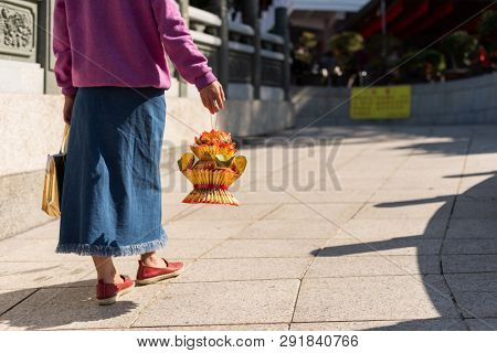 Nantou, Taiwan - FEB 8th, 2019: woman hold a lotus made by joss paper ready for burn at a Baohu Dimu Temple