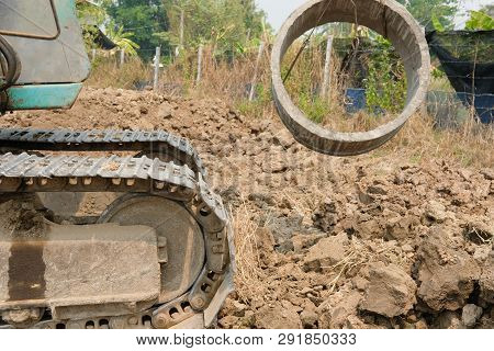 Excavator Backhoe Raising Pipe At Construction Site