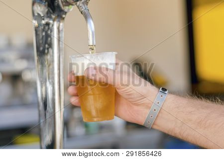 Man Pouring Fresh Beer In Self Service Bar - With All Inclusive Badge