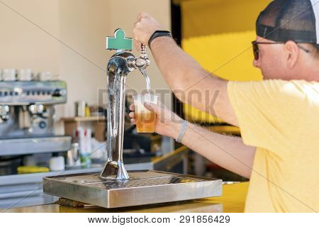 Man Pouring Fresh Beer In Self Service Bar - With All Inclusive Badge In The Resorts