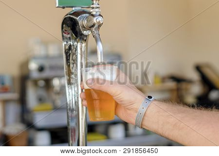 Man Pouring Fresh Beer In Self Service Bar - With All Inclusive Badge