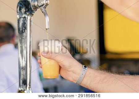 Man Pouring Fresh Beer In Self Service Bar - With All Inclusive Badge