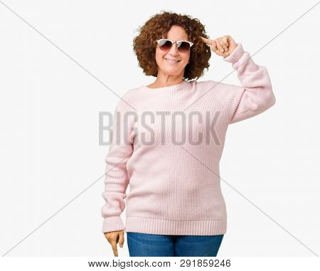 Beautiful middle ager senior woman wearing pink sweater and sunglasses over isolated background Smiling pointing to head with one finger, great idea or thought, good memory
