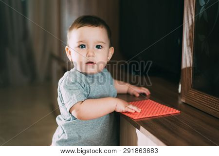 A Little Girl With A Rag Wiping The Dust From The Cabinet