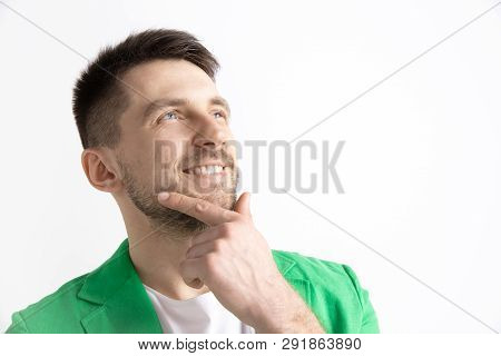 Looking For The Best Moment. Young Dreaming Smiling Man Is Waiting For Chanses Isolated On Gray Back