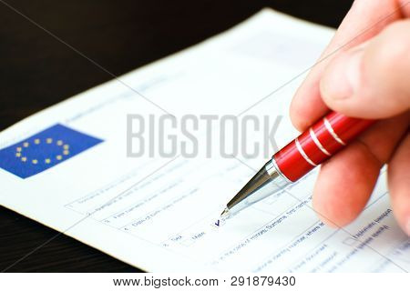 Schengen Visa, Questionnaire. Hand With Pen Completing A Questionary