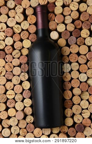 Red Wine: A bottle of cabernet sauvignon surrounded by corks standing on end filling the frame. Bottle has no label.