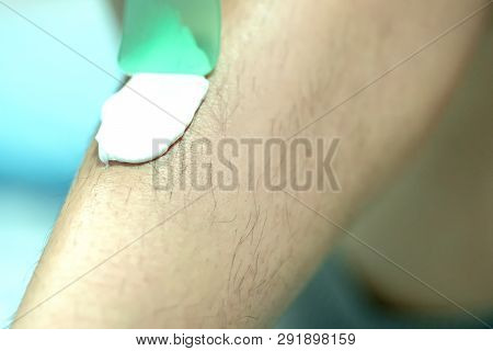 Woman Epilating Leg With Depilation Cream And Spatula. Scrubs Hair Removal Cream