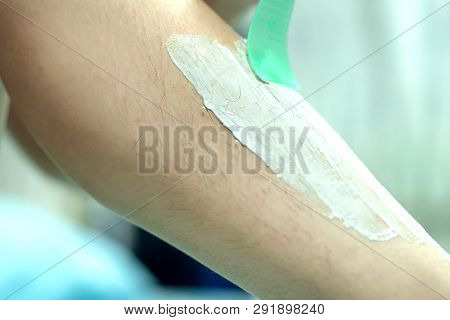 Woman Epilating Leg With Depilation Cream And Spatula. Scrubs Hair Removal Cream