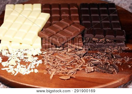 Chocolate In Diffrent Color. Milk, Dark And White Chocolate Bars On Table