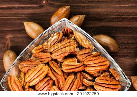 Pecan Nuts In The Shell With Pecan Kernel On Wooden Background