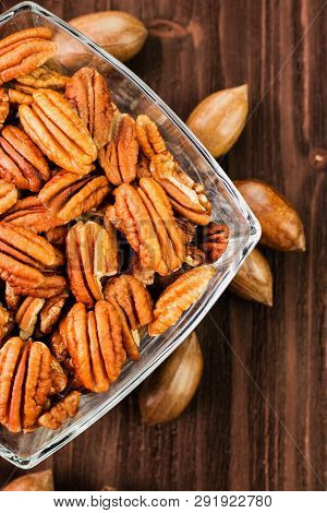 Pecan Nuts In The Shell With Pecan Kernel On Wooden Background