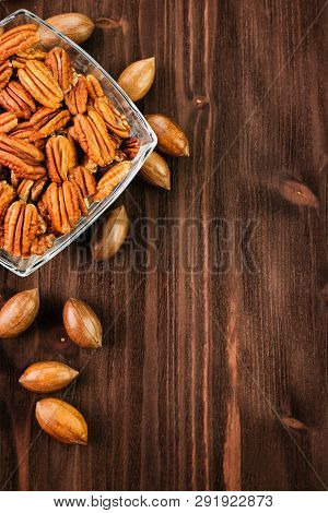 Pecan Nuts In The Shell With Pecan Kernel On Wooden Background