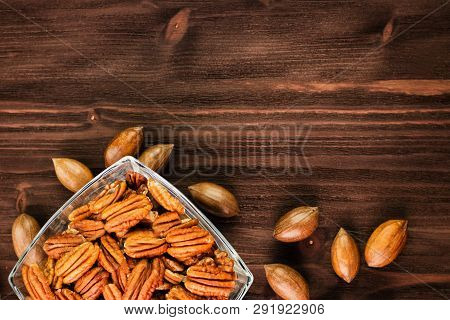 Pecan Nuts In The Shell With Pecan Kernel On Wooden Background