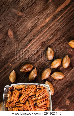 Pecan Nuts In The Shell With Pecan Kernel On Wooden Background