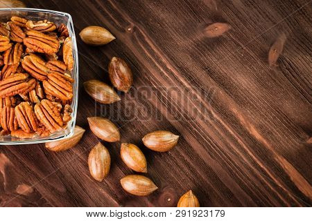 Pecan Nuts In The Shell With Pecan Kernel On Wooden Background