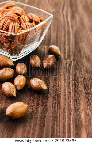 Pecan Nuts In The Shell With Pecan Kernel On Wooden Background