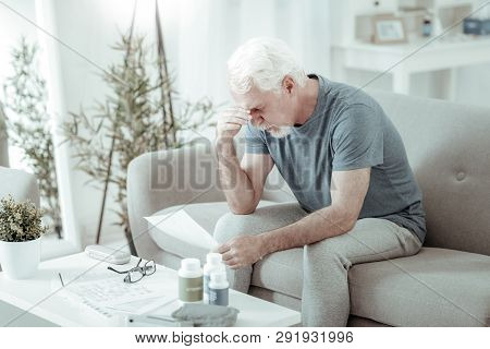 Sorrowful Grey-haired Patient Feeling Blue After Considering Assessment Of Doctor