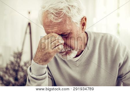 Old Sick Grey-haired Man In Beige Sweater Feeling Terrible Pain