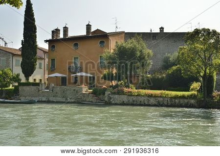 Buildings Along The Riverbanks In Borguetto, A Charming Village  Of The Province Of Verona, Italy.