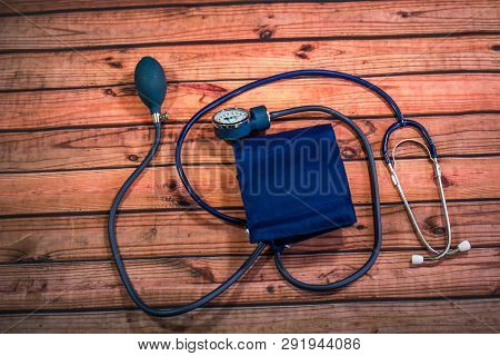 Blood Pressure Cuff, Stethoscope And Release Bulb On Wood Table