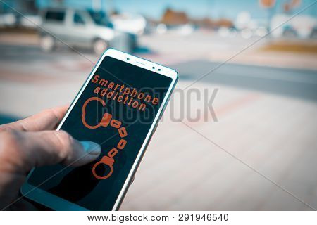 Hands Using A Smartphone With Handcuffs And Smartphone Addiction Words On Screen