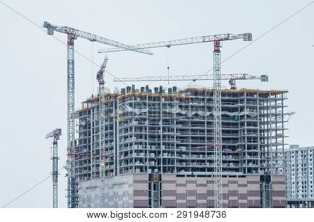Construction Site Background. Hoisting Cranes And New Multi-storey Buildings. Industrial Background.