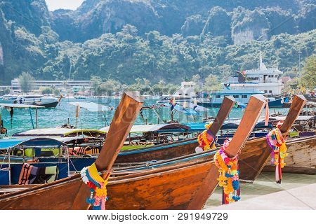 A Lot Of Long Tail Boats On Tropical Beach. Moored In The Port On The Asian Island.