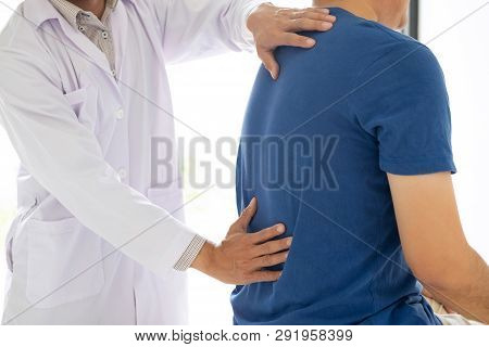 Doctor Physiotherapist Treating Lower Back Pain Patient After While Giving Exercising Treatment On S