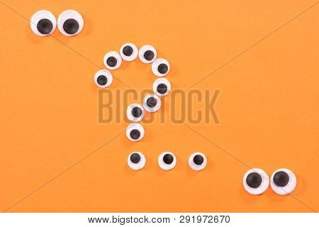 Googly Eyes. Two Strange Persons With Mad Eyes Look At Some Crazy Toy Eyes On Orange Background In T