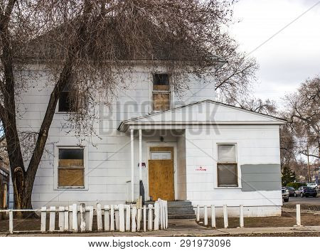 Abandoned Two Story Home With Boarded Up Door And Windows