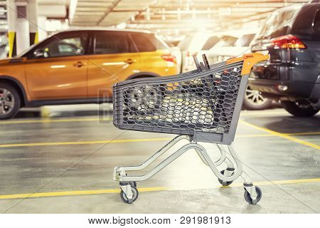 Modern Plastic Empty Shopping Cart Left At Roofed Underground Parking Of Shopping Mall. Supermarket 