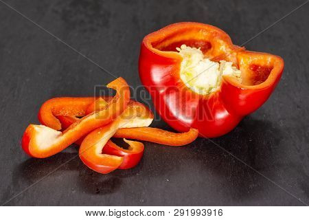 Group Of One Half Four Slices Of Bulgarian Red Bell Pepper On Grey Stone