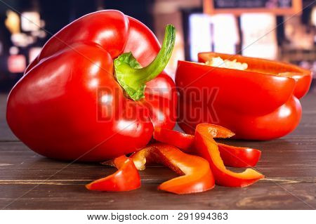 Group Of One Whole One Half Four Slices Of Bulgarian Red Bell Pepper With Restaurant In Background
