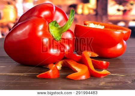 Group Of One Whole One Half Three Slices Of Bulgarian Red Bell Pepper With Rustic Wood Kitchen In Ba