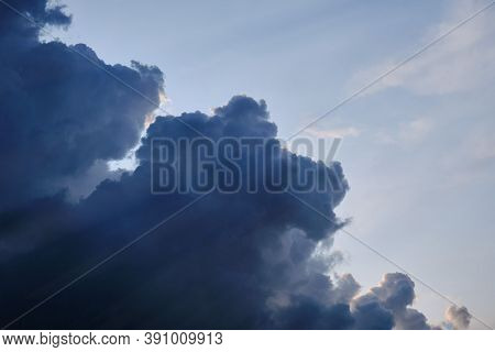 Beautiful Volumetric Clouds In The Rays Of Sunlight, Copy Space. Dark Storm Clouds And Clear Blue Sk