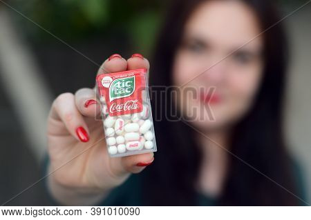 Young Girl Holds Tic-tac Hard Mints Pack With Coca-cola Taste. Tic Tac Is A Brand Of Small Hard Mint