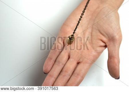 Hand-held Pendulum Over The Arm Of A Dowser. Selective Focus.