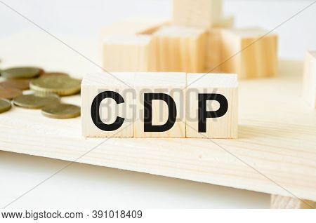 The Word Is Written On Wooden Cubes, In The Background Is A Mountain Of Cubes With Coins. The Word C