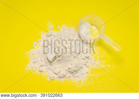 Measuring Cup From A White Powder Whey Protein On A Yellow Background