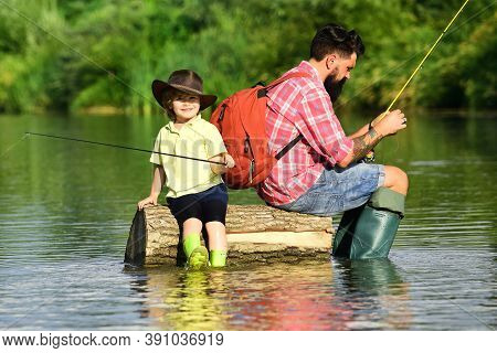 Father And Son Fishing - Family Time Together. Happy Father And Son Fishing In River Holding Fishing