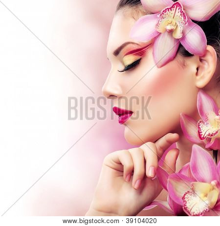 Krásná dívka s orchidejí Flowers.Beauty Model žena tváří. Dokonalá pleť. Profesionální Make-up.Makeu