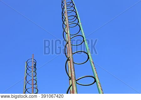 Two Towers Of Rebar Rising Against The Blue Sky