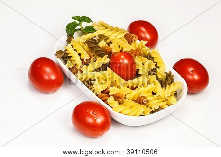 macarrão espiral de 3 cores com tomate cereja e folha de hortelã.