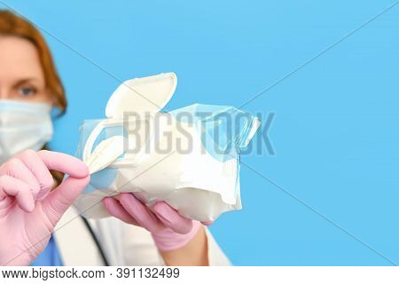 A Doctor In A White Uniform Holds Wet Wipes On A Blue Background, Copy Space., One
