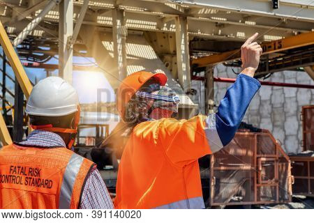 miner at a diamond mine with his African colleague pointing up