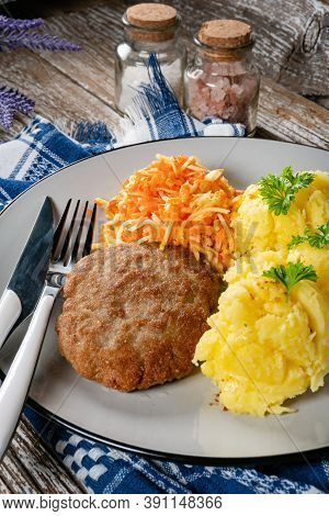 Homemade Minced Meat Cutlet Served With Mashed Potatoes And Carrot Salad.
