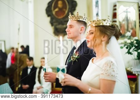Bride And Groom Holding Candles In Church
